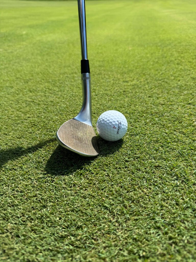 Picture showing a tight lie with golf ball and sand wedge